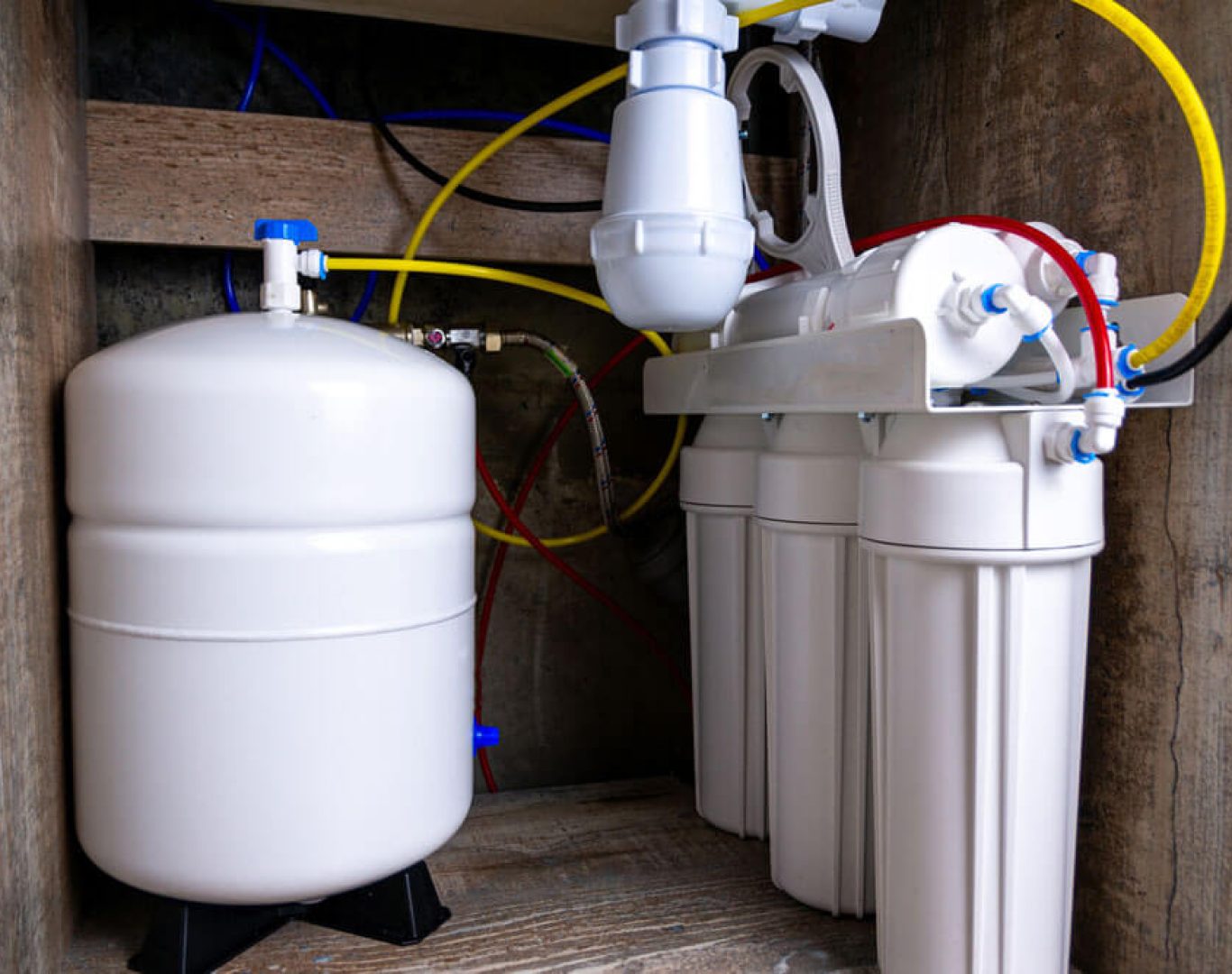 Technician installing a water filtration system in an Oceanside, CA home
